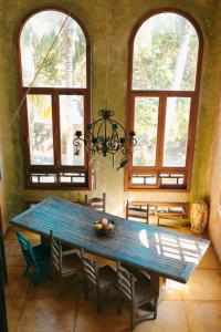 a dining room with a blue table and two windows at Zamas Hotel in Tulum