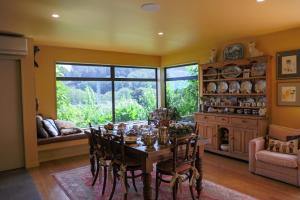 a dining room with a table and chairs and a window at Ballymoney Cnoc in Tai Tapu