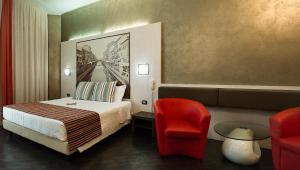 Habitación de hotel con cama y silla roja en Hotel Milano Navigli, en Milán