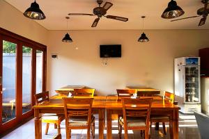 a dining room with a wooden table and chairs at Sweet Corner Guest House in Sanur