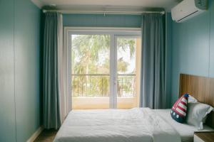 a bedroom with a bed and a large window at Saipan Emerald Villa in Saipan