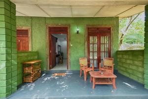 a room with a table and chairs on a green wall at Jays Holiday Resort in Habarana