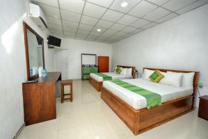 a bedroom with two beds and a desk and a television at Jays Holiday Resort in Habarana +63 photos