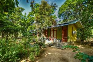 a yellow house in the middle of a forest at Jays Holiday Resort in Habarana
