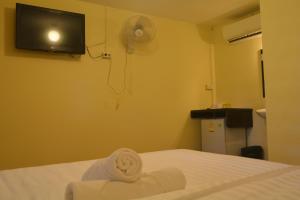 a room with a bed and a tv on the wall at M&M Guesthouse in Ko Chang