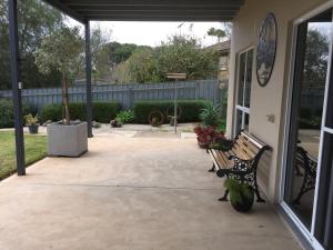 
a patio area with a bench and a walkway at Lyreen's Apartment in Auburn
