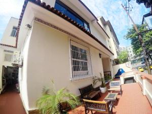 Un balcón de una casa con bancos y una ventana en DS Hostel, en Río de Janeiro