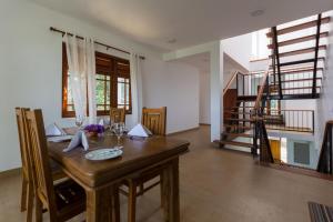 a dining room with a wooden table and stairs at Villa Mount Melody in Kandy