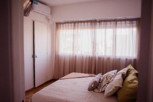 1 dormitorio con 1 cama y una ventana con cortinas en Departamento temporal Colon 401 en Córdoba