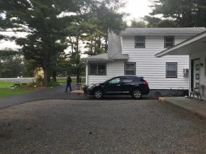 un coche negro estacionado frente a una casa en Catskill Motor Court, en Catskill