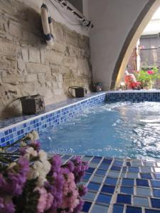 a swimming pool with a stone wall and blue tiles at Stratos ArtDeco House in Kalavasos +69 photos
