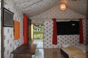 a room with a table and a tv in a room at Camp Serai Tiger TADOBA in Chandrapur