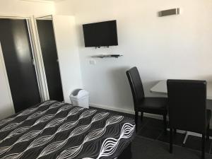 um quarto de hotel com uma cama, uma mesa e uma televisão em Budget on the Lake em Hamilton