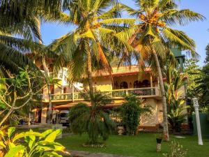 a hotel with palm trees in front of it at Shangri-lanka Villa in Bentota