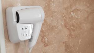 a white soap dispenser on a wall in a bathroom at Pensiunea Groza in Târgu Jiu