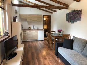 a kitchen and a living room with a couch and a table at Tulipán-Apartman in Eger