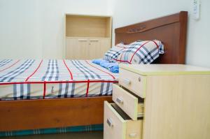 a bedroom with a bed and some drawers at The MONDAY APARTMENT in Ho Chi Minh City