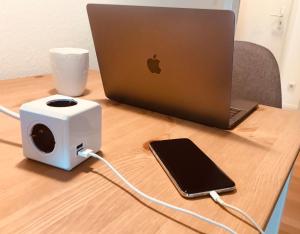 a laptop computer with a speaker and a cell phone on a desk at Bed & Kitchen in Gießen