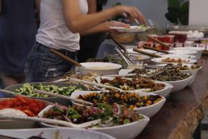 - un buffet avec de nombreuses assiettes de nourriture sur une table dans l'établissement Bait Alfa Kibbutz Country Lodging, à Bet Alfa