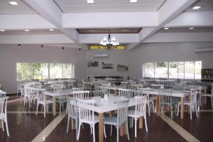 uma sala de jantar com mesas brancas e cadeiras brancas em Bait Alfa Kibbutz Country Lodging em Bet Alfa