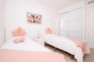 2 łóżka w sypialni z białymi ścianami i różowymi w obiekcie Royal Park w mieście Torrevieja +19 zdjęć