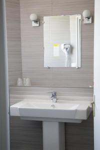 a bathroom with a white sink and a mirror at Hôtel Saint Antoine in Angoulême