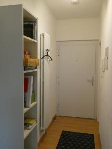 einen Flur mit einer weißen Tür und einem Teppich in der Unterkunft Gräftenblick in Münster
