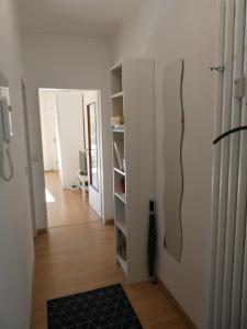 einen Flur mit einem Zimmer mit Tür und Bücherregal in der Unterkunft Gräftenblick in Münster