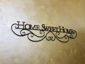 a sign that reads home sweet home on a wall at B&B Le Mansarde in Pescara