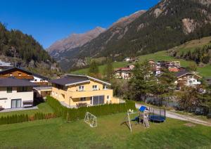 a house with a playground in a field with mountains at Appartement MonAlisa in Sölden
