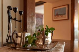 a table with a plate with a tea kettle and a candle at Hotel Simius Playa in Villasimius
