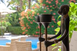 a statue of a person holding a light on a pole at Hotel Simius Playa in Villasimius
