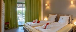2 Betten in einem Zimmer mit grünen Vorhängen in der Unterkunft VbyOnyx in Olmeto