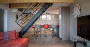 ein Wohnzimmer mit einer Treppe und roten Stühlen in der Unterkunft VbyOnyx in Olmeto