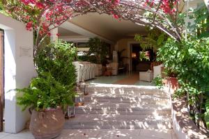 a walkway leading to a garden filled with plants at Hotel Simius Playa in Villasimius