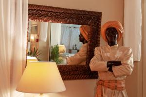 a statue of a woman in front of a mirror at Hotel Simius Playa in Villasimius