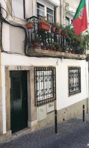 een gebouw met een balkon met potplanten en een vlag bij PS Lisbon Flats in Lissabon