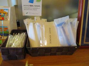 a black basket filled with plastic utensils on a table at Hotel Green Well in Sendai