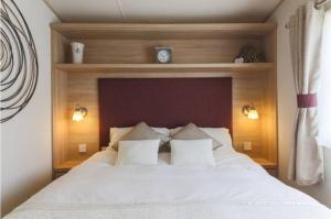 una camera da letto con un grande letto bianco con due cuscini di Blenheim, Padstow a Padstow