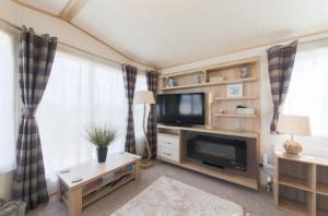 a living room with a television and a fireplace at Blenheim, Padstow in Padstow