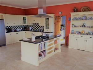 a large kitchen with white cabinets and a counter top at ocean view in Wexford