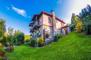 an old stone house on a green lawn at Mylos in Arkochórion