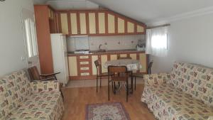 sala de estar con 2 sofás, mesa y cocina en Cicek Hotel & Apartments, en Fethiye