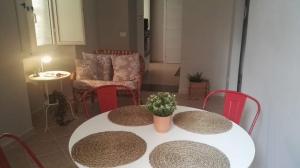 un tavolo bianco con sedie rosse e un tavolo con una pianta sopra di Profumo di Mora guesthouse a Torre del Greco