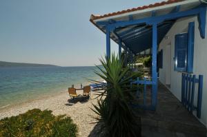 Mourterón的住宿－Seahorse cottage，海滩上,有椅子,还有一座建筑和大海