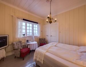 una camera con letto, tavolo e lampadario a braccio di Arctic Garden a Lødingen