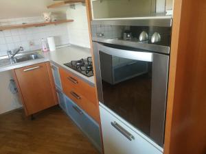 una cocina con horno de acero inoxidable y fregadero en Peaceful 4-room house in Maribor's green garden, en Maribor