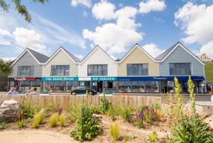 a building with a fence and flowers in front of it at Roker Seafront Apartments in Sunderland