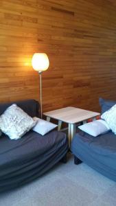 um quarto com dois sofás e uma mesa com um candeeiro em Chamrousse 1750 - Le Taillefer - Appartement classé 3 étoiles em Chamrousse