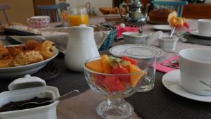 a table with a glass bowl of fruit on it at Le Moulin de l'Ortille & SPA in Compiègne